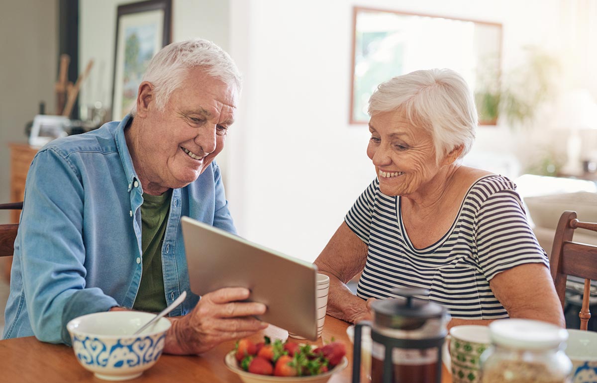 Elderly couple answering survey on table