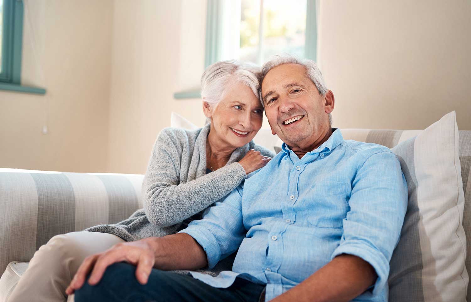 Elderly couple enjoying sitting on a sofa