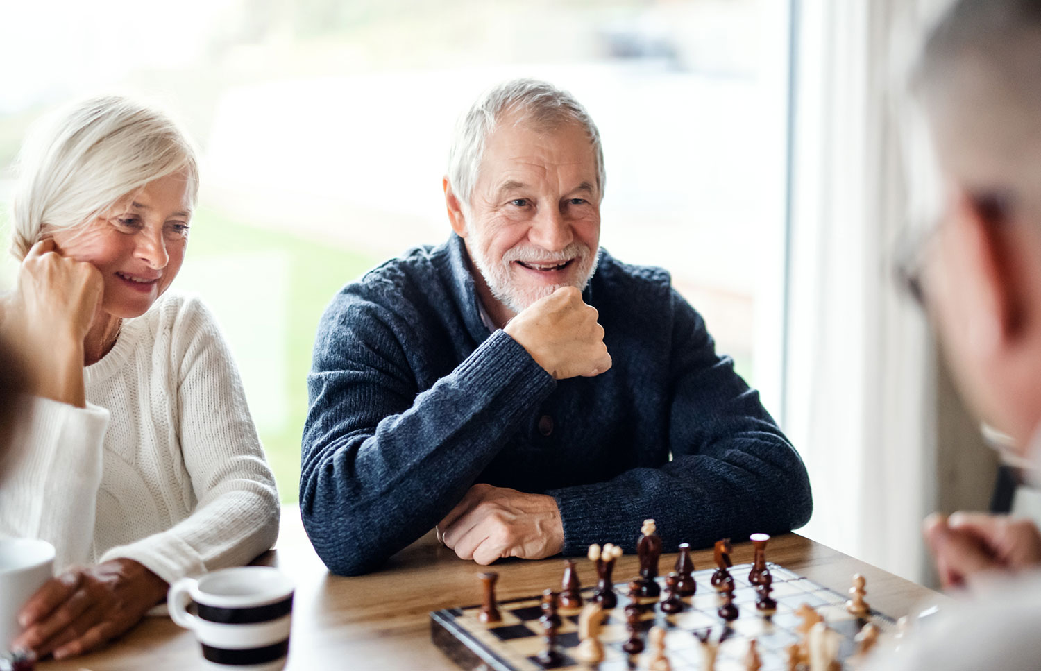 Elderly people enjoying game of chess in retirement village