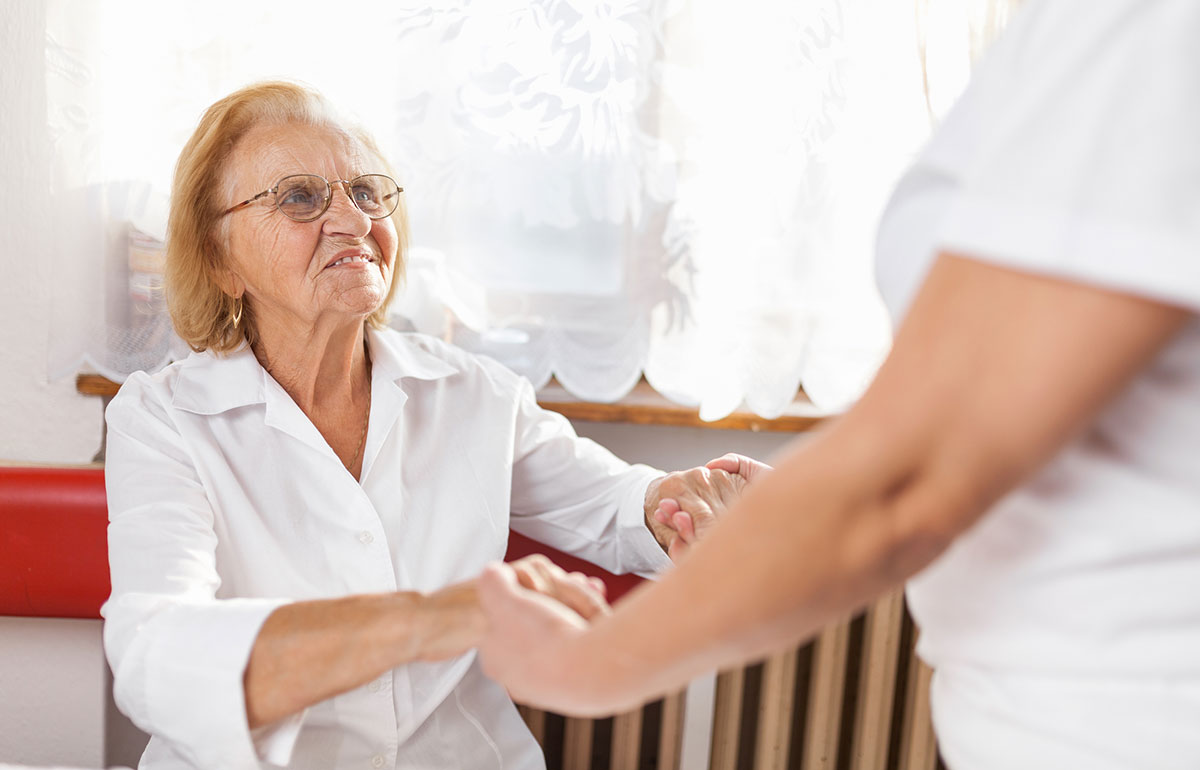 Aged care resident is assisted to stand by carer