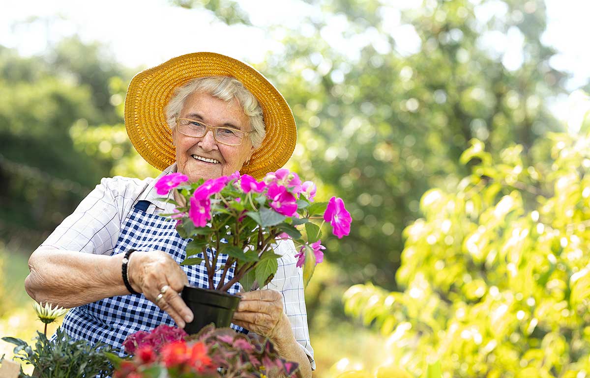 Happy elderly woman woman outdoors at Aged Care facility